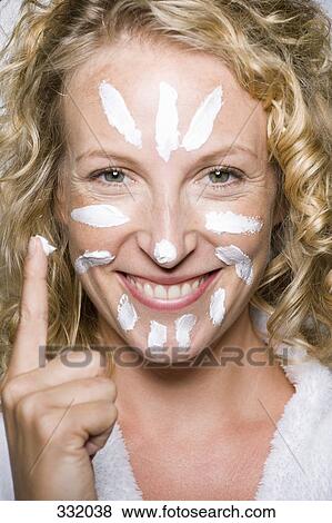 Woman applying moisturizer to face View Large Photo Image Stock Photo - Woman applying moisturizer to face. Fotosearch
