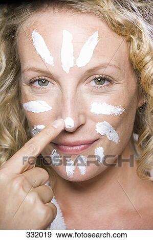 Woman applying moisturizer to her face View Large Photo Image Stock Photo - Woman applying moisturizer to her face. Fotosearch
