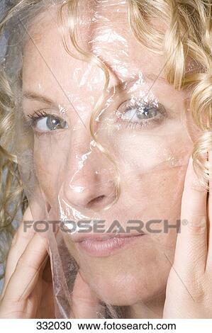 Woman holding transparent sheet over her face View Large Photo Image Stock Image - Woman holding transparent sheet over her face. Fotosearch