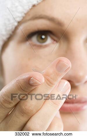 Woman putting in a contact lens View Large Photo Image Stock Image - Woman putting in a contact lens. Fotosearch