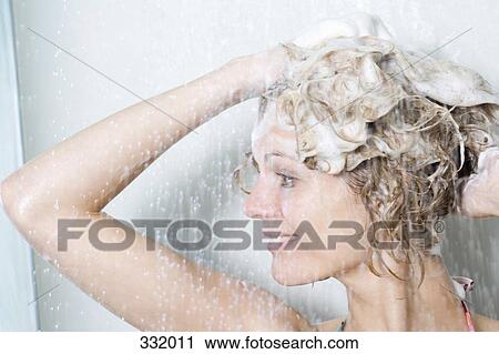 Stock Image - Woman washing her hair in the shower. Fotosearch