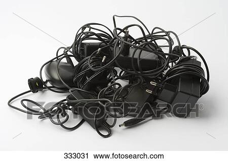 Stock Image - Bundle of mobile phone battery chargers. Fotosearch