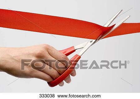 Stock Photo - Person cutting red ribbon with scissors. Fotosearch