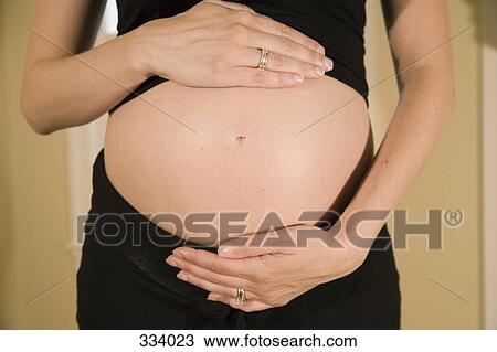 Midsection view of a pregnant woman View Large Photo Image Stock Image - Midsection view of a pregnant woman. Fotosearch