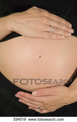 Midsection view of a pregnant woman View Large Photo Image Stock Photo - Midsection view of a pregnant woman. Fotosearch