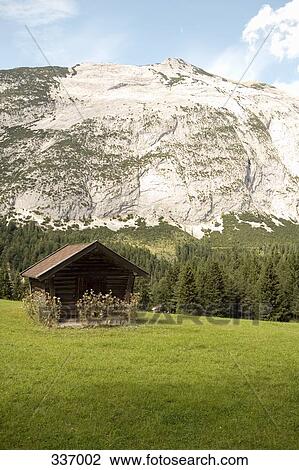 Stock Image - Small hut with mountain in background. Fotosearch