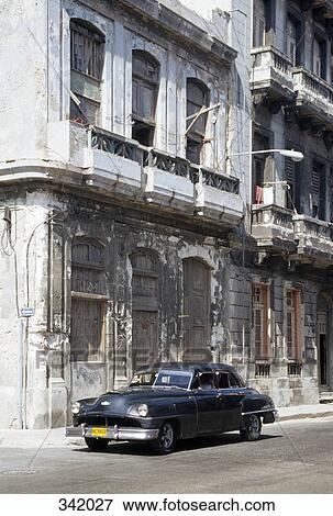 Vintage car parked in front of run-down building, Havana, Cuba View Large Photo Image Stock Photo - Vintage car parked in front of run-down building, Havana, Cuba. Fotosearch