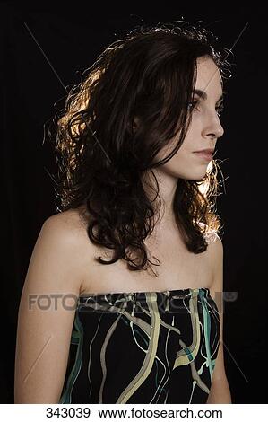 Portrait of young woman with curly hair looking away View Large Photo Image Stock Photo - Portrait of young woman with curly hair looking away. Fotosearch