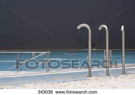 Stock Photo - Showers next to indoor swimming pool at tropical theme park. Fotosearch