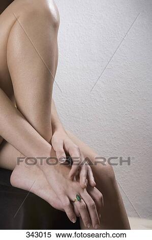 Woman sitting with leg curled up on chair View Large Photo Image Stock Photography - Woman sitting with leg curled up on chair. Fotosearch