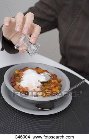 Man holding empty salt shaker above ruined meal View Large Photo Image Picture - Man holding empty salt shaker above ruined meal. Fotosearch