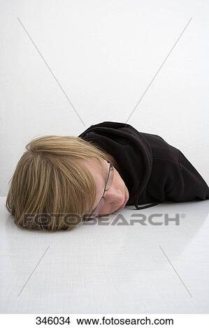 Young man resting head on table View Large Photo Image Picture - Young man resting head on table. Fotosearch
