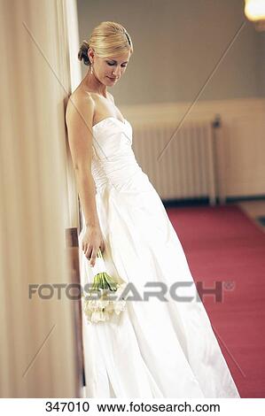 Bride leaning against pillar and looking down View Large Photo Image Stock Image - Bride leaning against pillar and looking down. Fotosearch