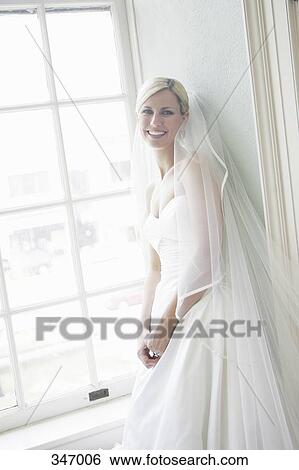 Bride standing by window View Large Photo Image Stock Photograph - Bride standing by window. Fotosearch