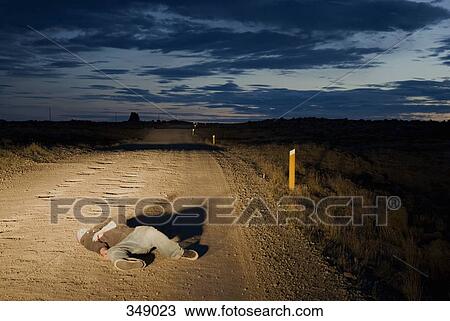 Stock Image - Body lying in road. Fotosearch
