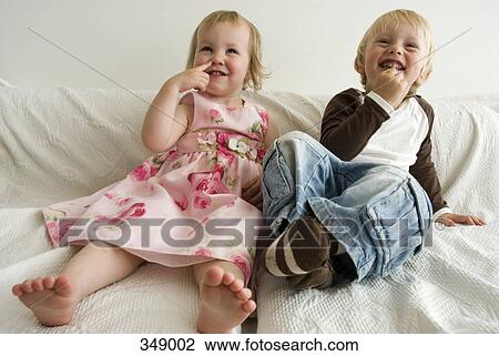 Brother and sister sitting on sofa and laughing View Large Photo Image Stock Image - Brother and sister sitting on sofa and laughing. Fotosearch