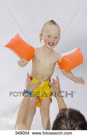 Father throwing son into the air from a swimming pool View Large Photo Image Picture - Father throwing son into the air from a swimming pool. Fotosearch