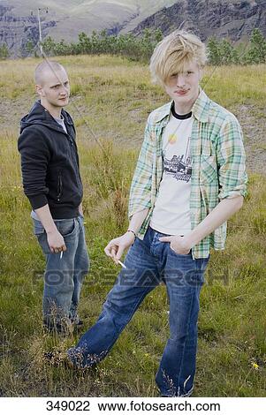Two young men smoking in field View Large Photo Image Stock Image - Two young men smoking in field. Fotosearch