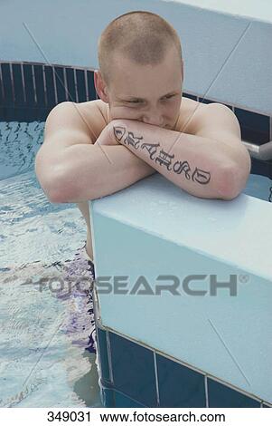 Young man leaning against the edge of a swimming pool View Large Photo Image Stock Image - Young man leaning against the edge of a swimming pool. Fotosearch