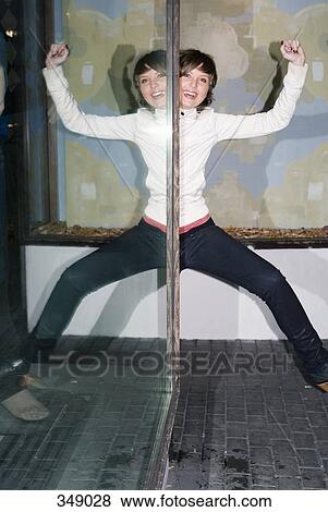 Young woman posing nest to her reflection in a shop window View Large Photo Image Stock Photo - Young woman posing nest to her reflection in a shop window. Fotosearch