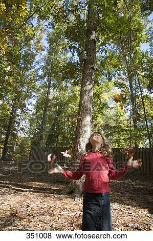 Girl playing with leaves in autumn View Large Photo Image Stock Photo - Girl playing with leaves in autumn. Fotosearch