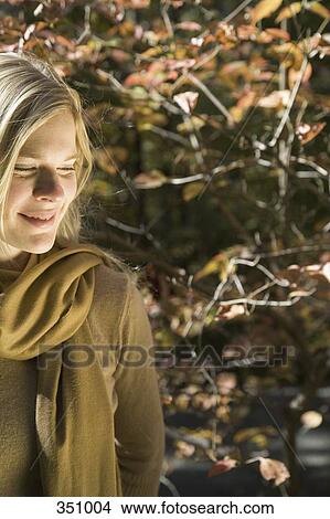 Woman standing in a forest in autumn and smiling View Large Photo Image Picture - Woman standing in a forest in autumn and smiling. Fotosearch