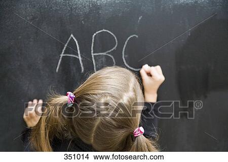Young child writing on chalkboard View Large Photo Image Picture - Young child writing on chalkboard. Fotosearch