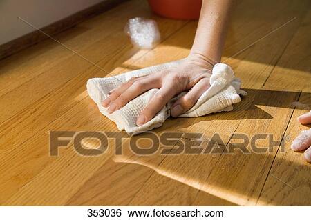 Stock Photograph - Hand clean wooden floor with rag. Fotosearch