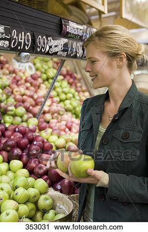Woman choosing apples in a supermarket View Large Photo Image Stock Image - Woman choosing apples in a supermarket. Fotosearch