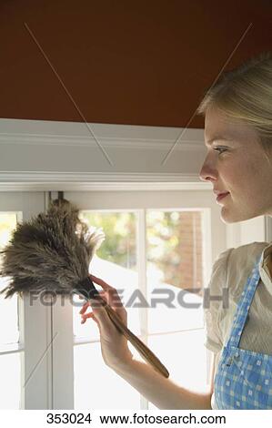 Picture - Woman dusting in home. Fotosearch