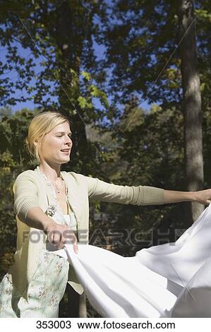 Stock Image - Woman holding laundry outdoors. Fotosearch