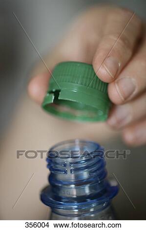 Close-up of hand opening bottle View Large Photo Image Picture - Close-up of hand opening bottle. Fotosearch