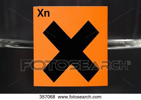 Stock Photo - ‘Harmful effects’ warning label on glass flask containing liquid. Fotosearch