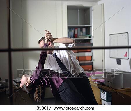 Man and woman dancing in office View Large Photo Image Stock Photo - Man and woman dancing in office. Fotosearch