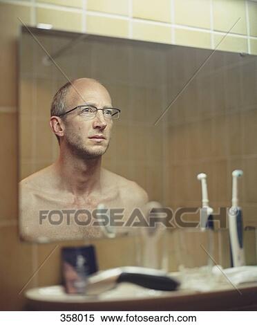 Man staring at reflection in bathroom mirror View Large Photo Image Stock Photography - Man staring at reflection in bathroom mirror. Fotosearch