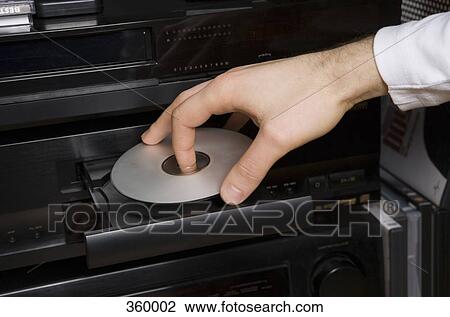 Man inserting disk into DVD player View Large Photo Image Stock Image - Man inserting disk into DVD player. Fotosearch