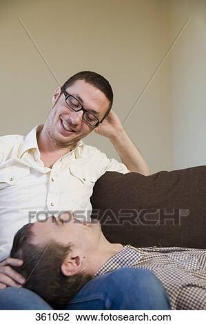 Gay couple relaxing on sofa together View Large Photo Image Stock Image - Gay couple relaxing on sofa together. Fotosearch
