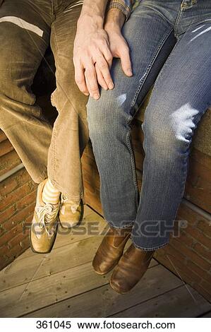 Stock Photography - Low section of two men holding hands. Fotosearch