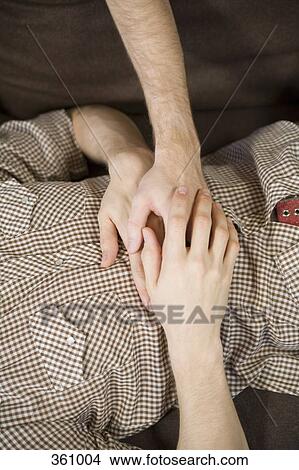 Picture - Midsection view of homosexual couple holding hands. Fotosearch
