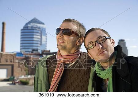 Two gay men smiling with cityscape behind View Large Photo Image Stock Photo - Two gay men smiling with cityscape behind. Fotosearch
