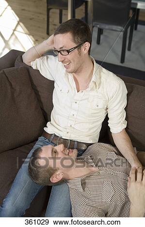 Stock Photo - Two homosexual men relaxing on the sofa. Fotosearch