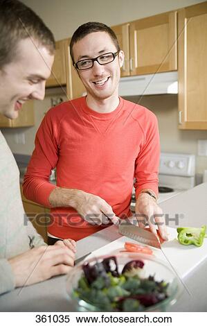 Two men preparing vegetables in kitchen together View Large Photo Image Stock Photography - Two men preparing vegetables in kitchen together. Fotosearch
