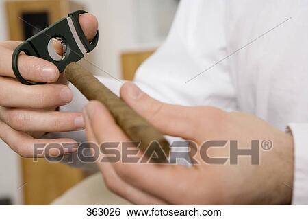 Man holding cigar and cutters View Large Photo Image Stock Photograph - Man holding cigar and cutters. Fotosearch