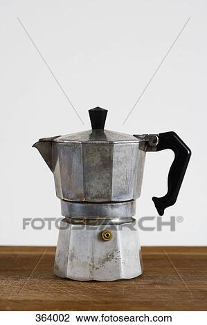 Stock Image - Coffee percolator on wooden cutting board. Fotosearch