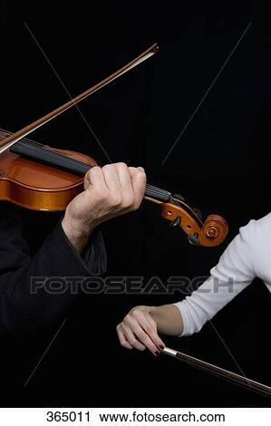 Man playing a violin and a woman playing a cello View Large Photo Image Stock Image - Man playing a violin and a woman playing a cello. Fotosearch