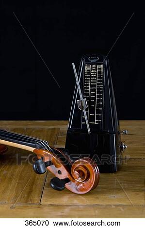 Metronome and violin on wooden table View Large Photo Image Stock Image - Metronome and violin on wooden table. Fotosearch