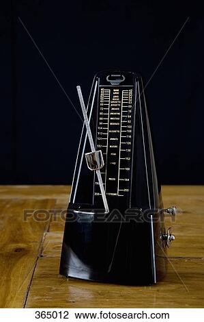 Stock Image - Metronome on wooden bench. Fotosearch
