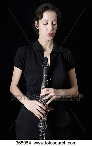 Woman holding a clarinet View Large Photo Image Picture - Woman holding a clarinet. Fotosearch