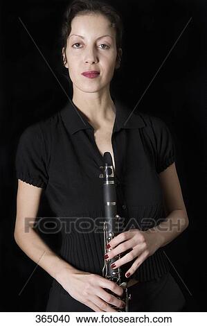 Woman holding a clarinet View Large Photo Image Stock Image - Woman holding a clarinet. Fotosearch