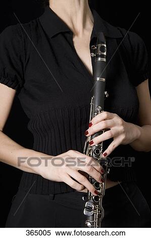 Woman holding a clarinet View Large Photo Image Stock Photography - Woman holding a clarinet. Fotosearch